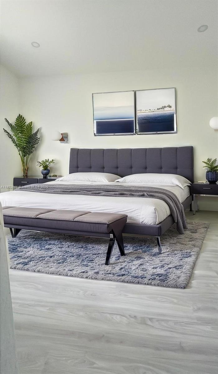 6972 Northwest 179th Street, Unit 2094 Hialeah, FL 33015 - Photo 5 of 10 a living room with a bed and a potted plant on table