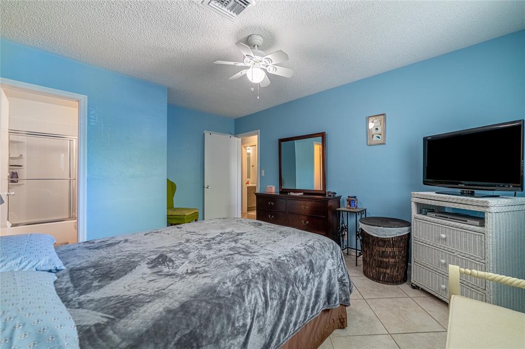 2100 Northeast 38th Street, Unit 216 Lighthouse Point, FL 33064 - Photo 15 of 27 a bedroom with a bed and a flat screen tv