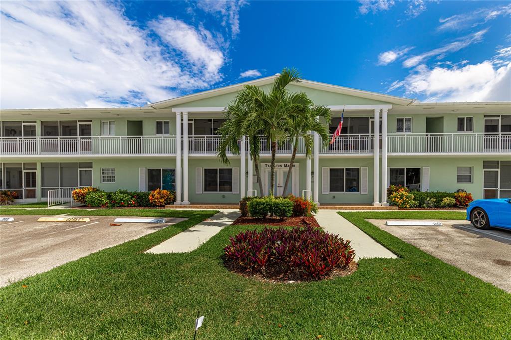 2100 Northeast 38th Street, Unit 216 Lighthouse Point, FL 33064 - Photo 21 of 27 a front view of a building with a garden