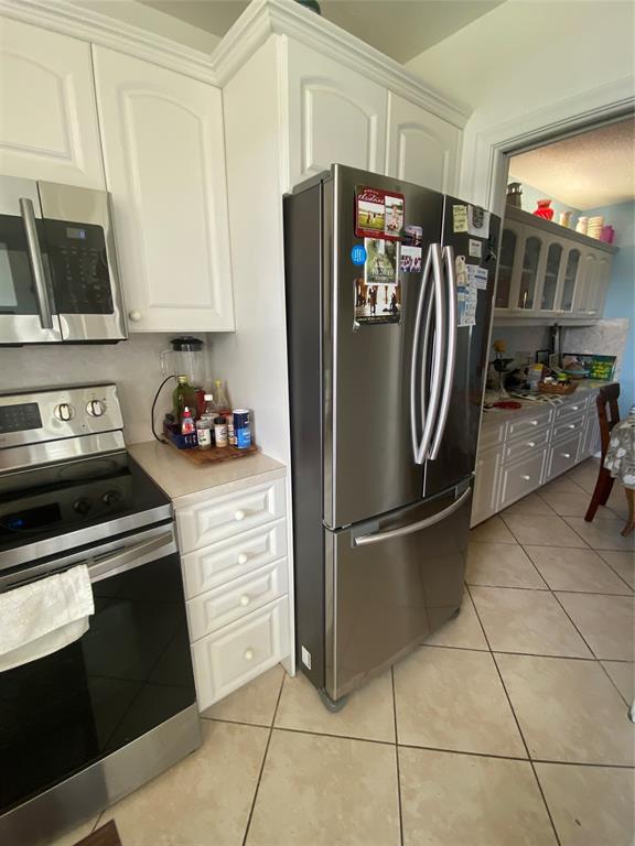 2100 Northeast 38th Street, Unit 216 Lighthouse Point, FL 33064 - Photo 24 of 27 a kitchen with stainless steel appliances granite countertop a refrigerator stove and microwave