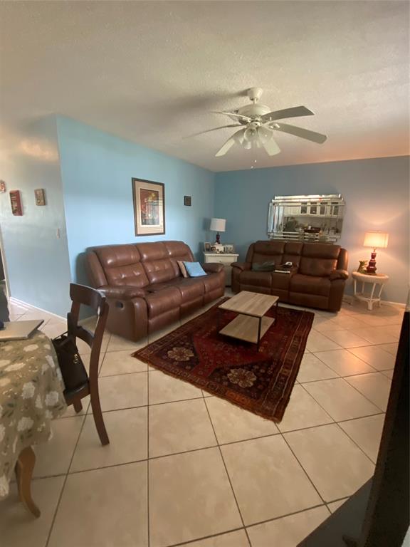2100 Northeast 38th Street, Unit 216 Lighthouse Point, FL 33064 - Photo 27 of 27 a living room with furniture and a chandelier
