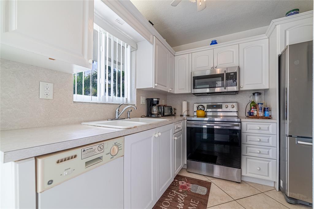 2100 Northeast 38th Street, Unit 216 Lighthouse Point, FL 33064 - Photo 5 of 27 a kitchen with stainless steel appliances granite countertop a refrigerator sink and stove