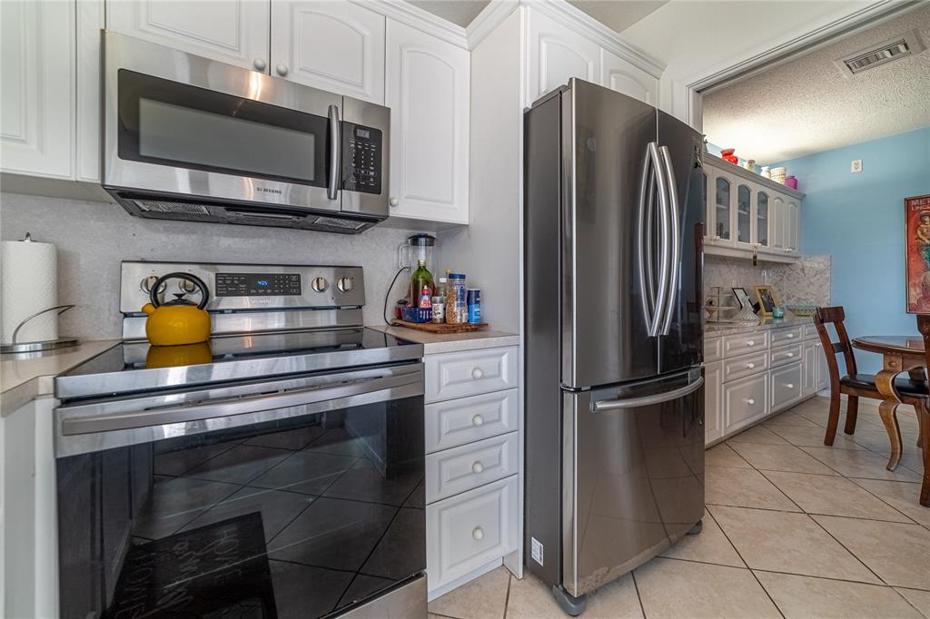 2100 Northeast 38th Street, Unit 216 Lighthouse Point, FL 33064 - Photo 6 of 27 a kitchen with appliances a sink and cabinets
