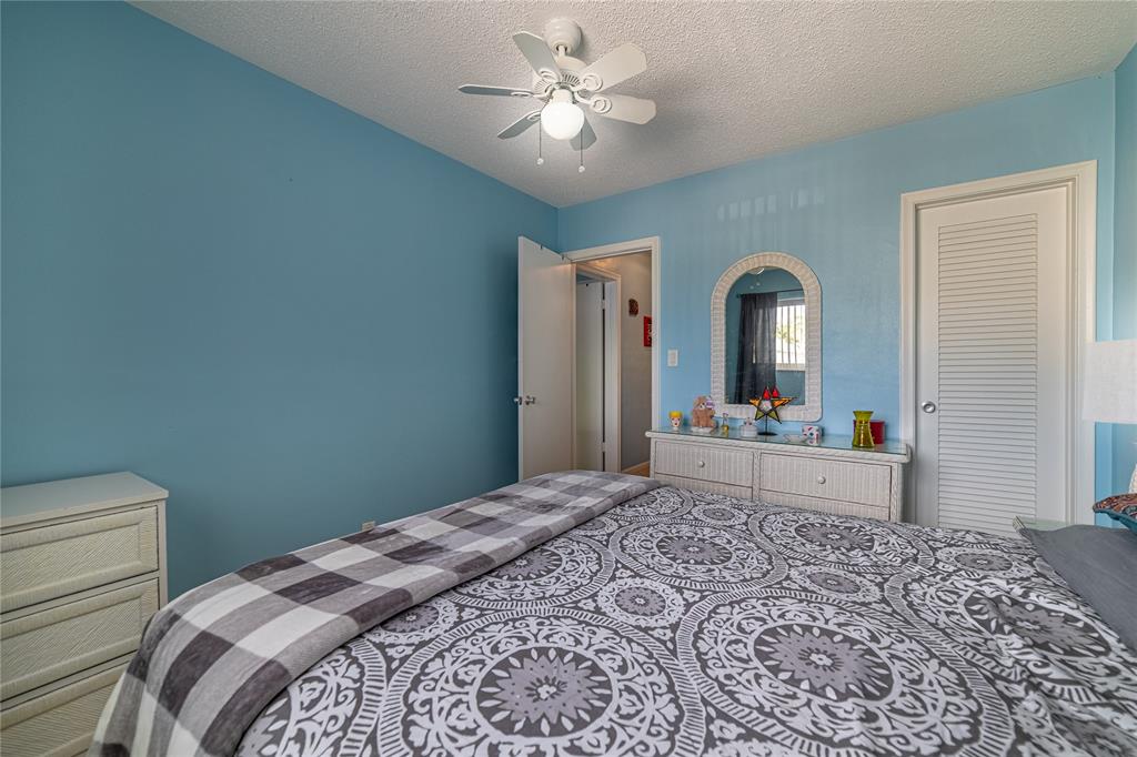 2100 Northeast 38th Street, Unit 216 Lighthouse Point, FL 33064 - Photo 9 of 27 a bedroom with a bed and a dresser with mirror