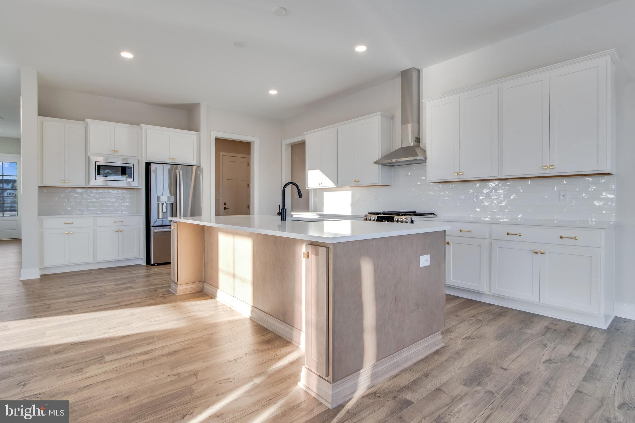 30491 Blue Beech Lane Frankford, DE 19945 - Photo 18 of 73 a kitchen with granite countertop white cabinets and stainless steel appliances