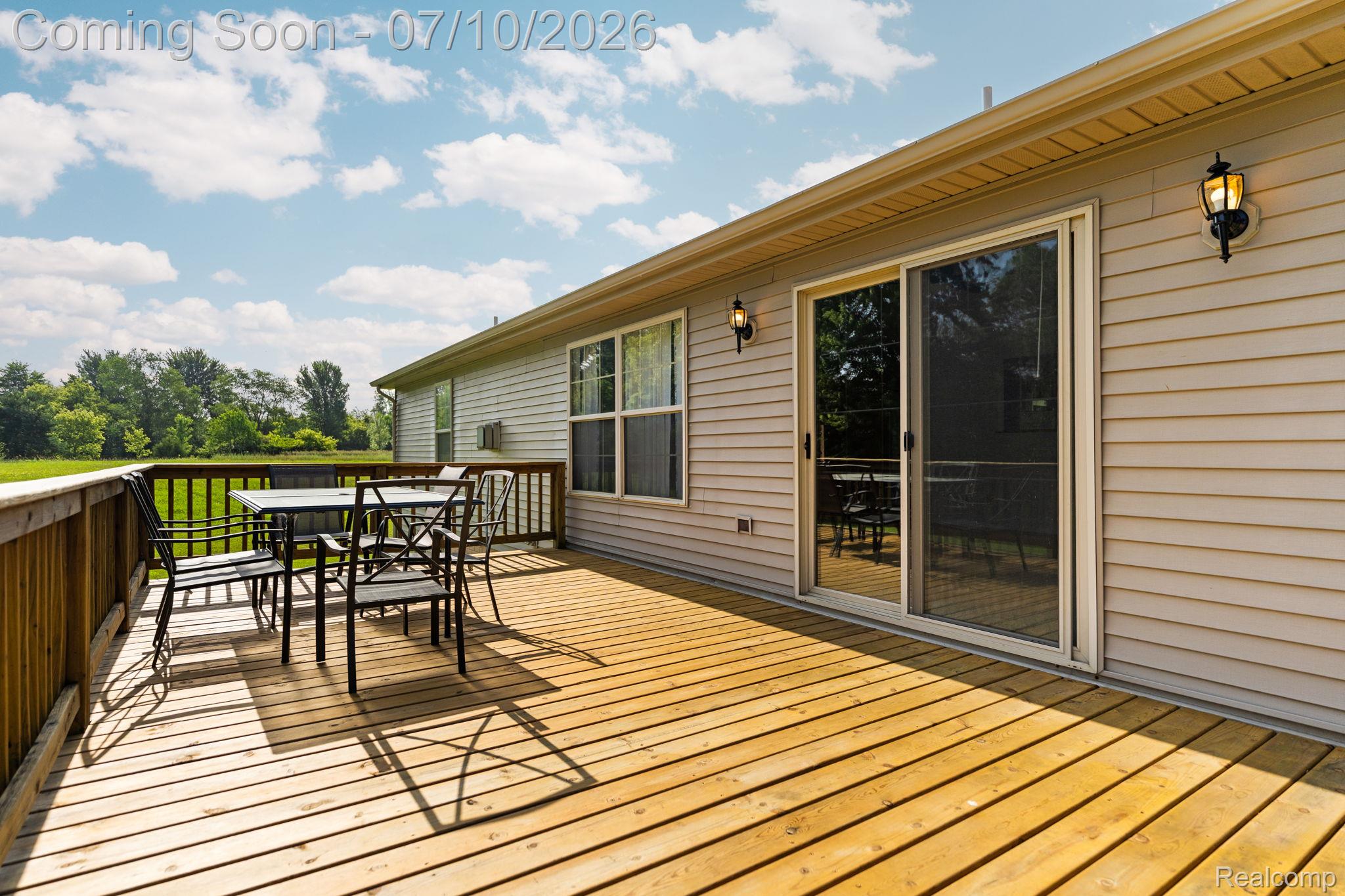 3144 North Nicholson Road Fowlerville, MI 48836 - Photo 25 of 70 Expansive wood deck featuring a protective railing and direct access to the interior via a sliding glass door