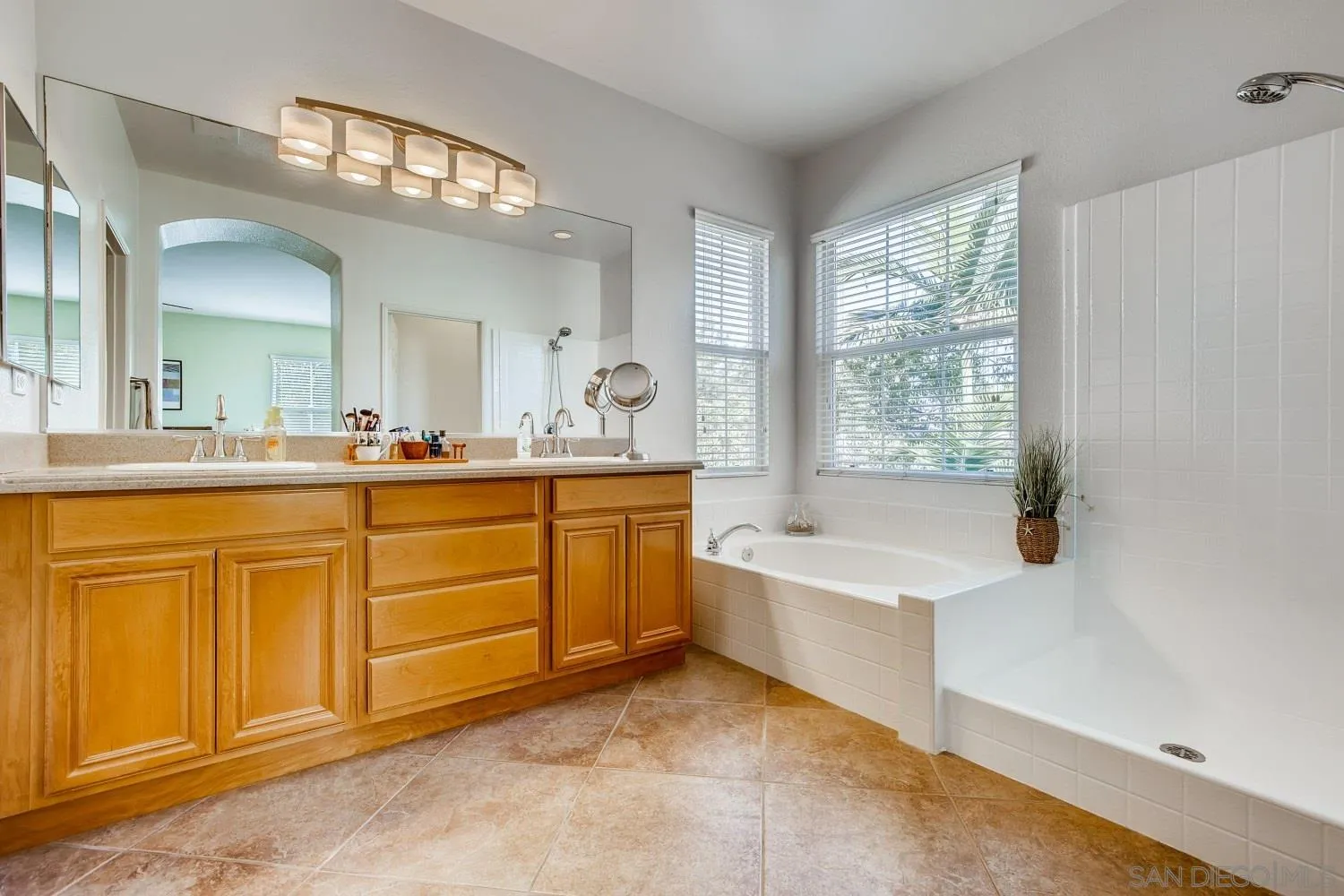 1332 Enchante Way Oceanside, CA 92056 - Photo 16 of 28 a spacious bathroom with a tub sink and mirror