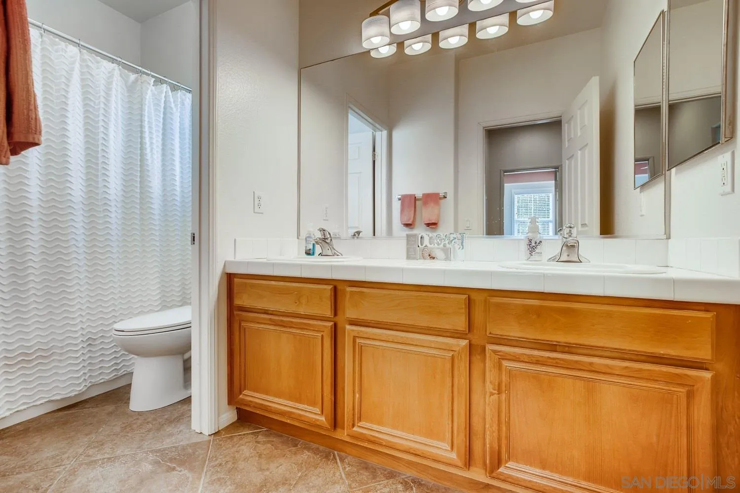 1332 Enchante Way Oceanside, CA 92056 - Photo 21 of 28 a bathroom with a granite countertop sink toilet and mirror