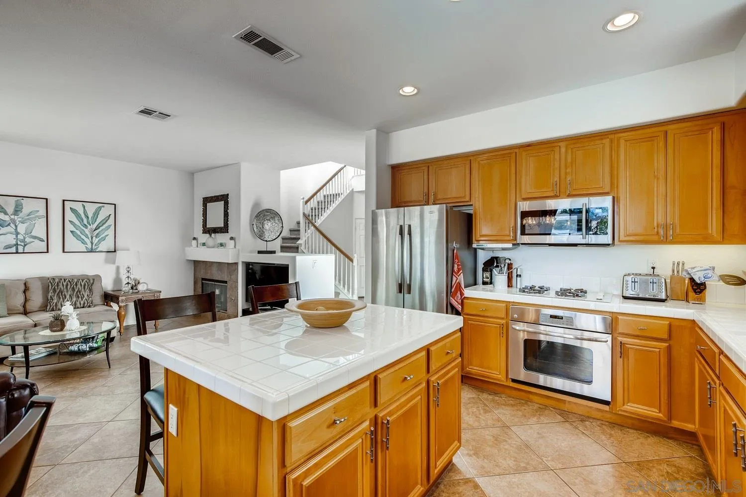 1332 Enchante Way Oceanside, CA 92056 - Photo 8 of 28 a kitchen with a sink a stove and chairs