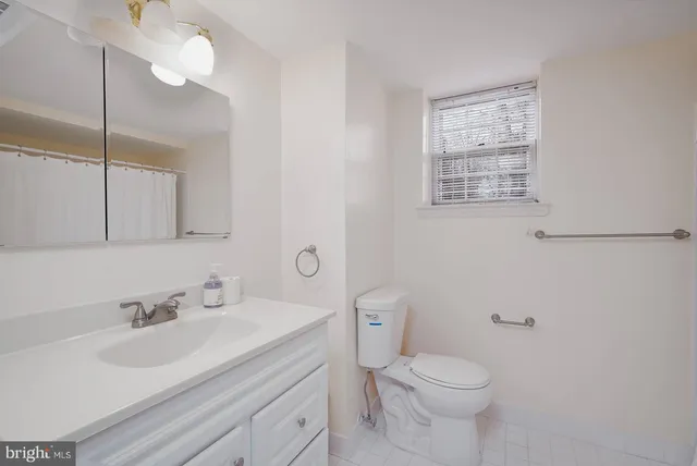 a bathroom with a sink vanity mirror and toilet