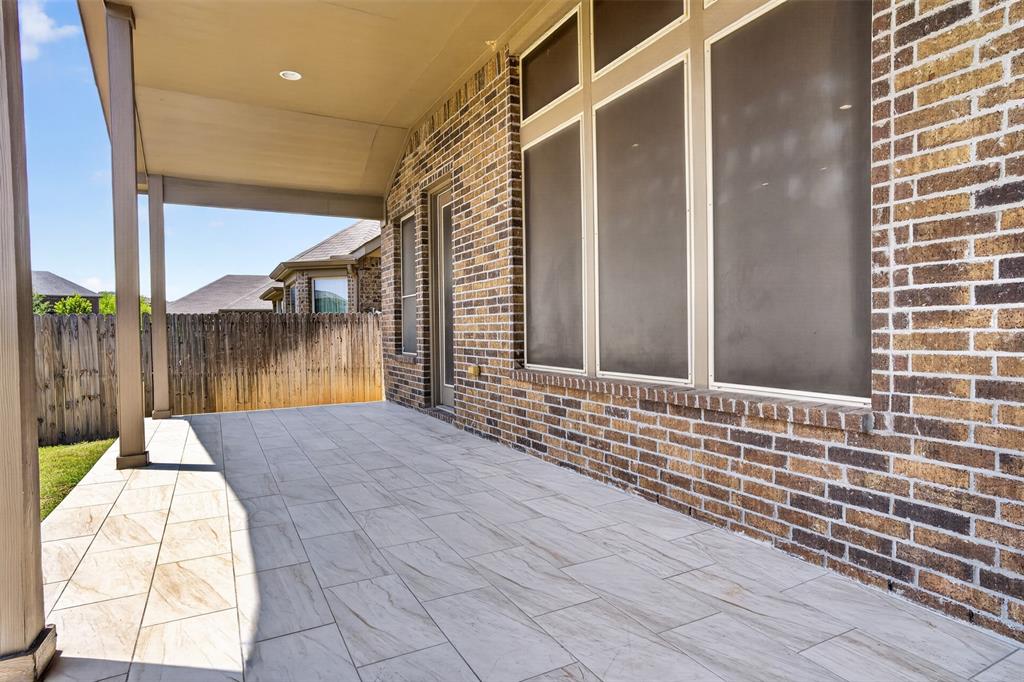 8728 Maple Ridge Trail Fort Worth, TX 76244 - Photo 5 of 40 Covered patio featuring a brick exterior and wood-look tile flooring