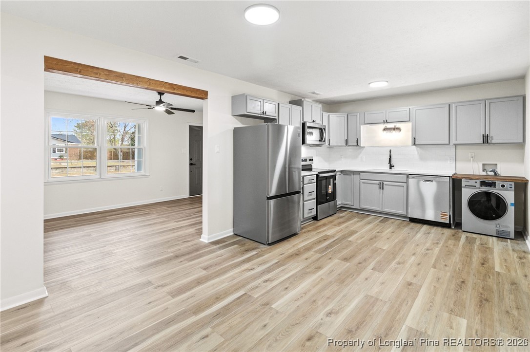 5982 Spinner Road Hope Mills, NC 28348 - Photo 12 of 32 a kitchen with stainless steel appliances granite countertop a refrigerator a stove and a wooden floors