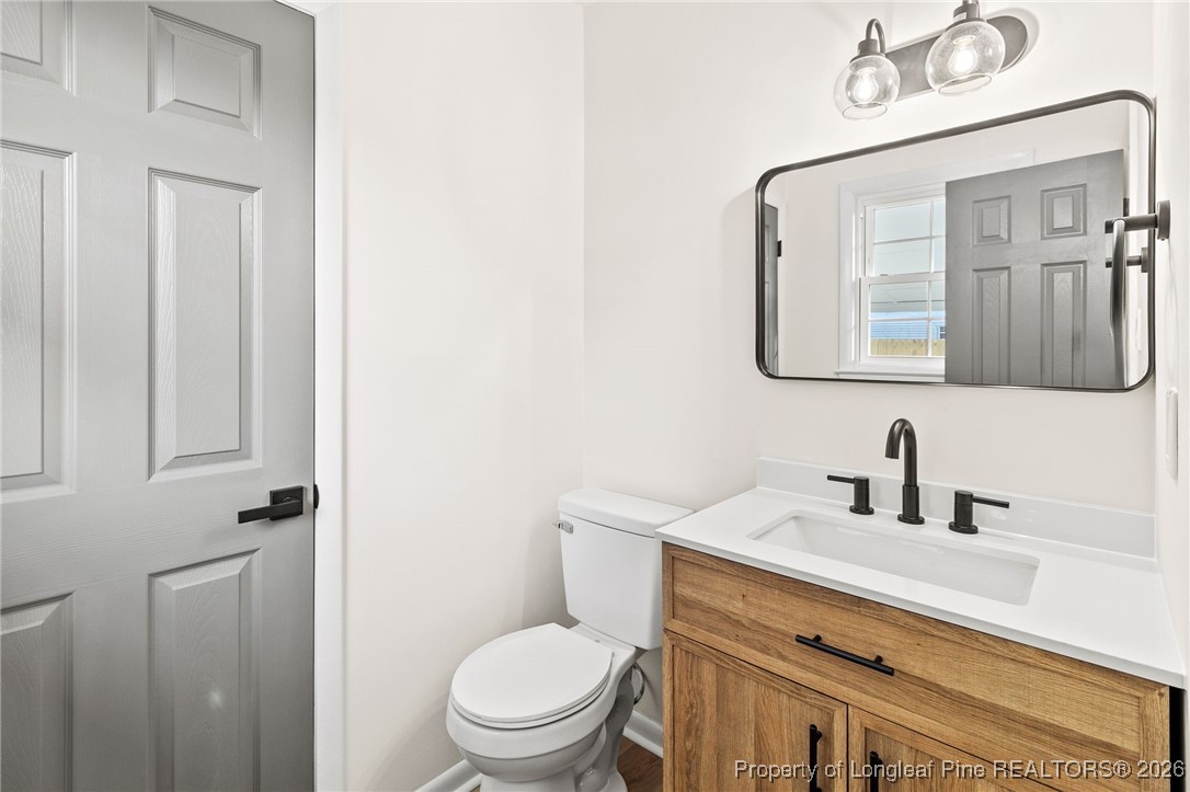 5982 Spinner Road Hope Mills, NC 28348 - Photo 20 of 32 a bathroom with a toilet a sink and mirror