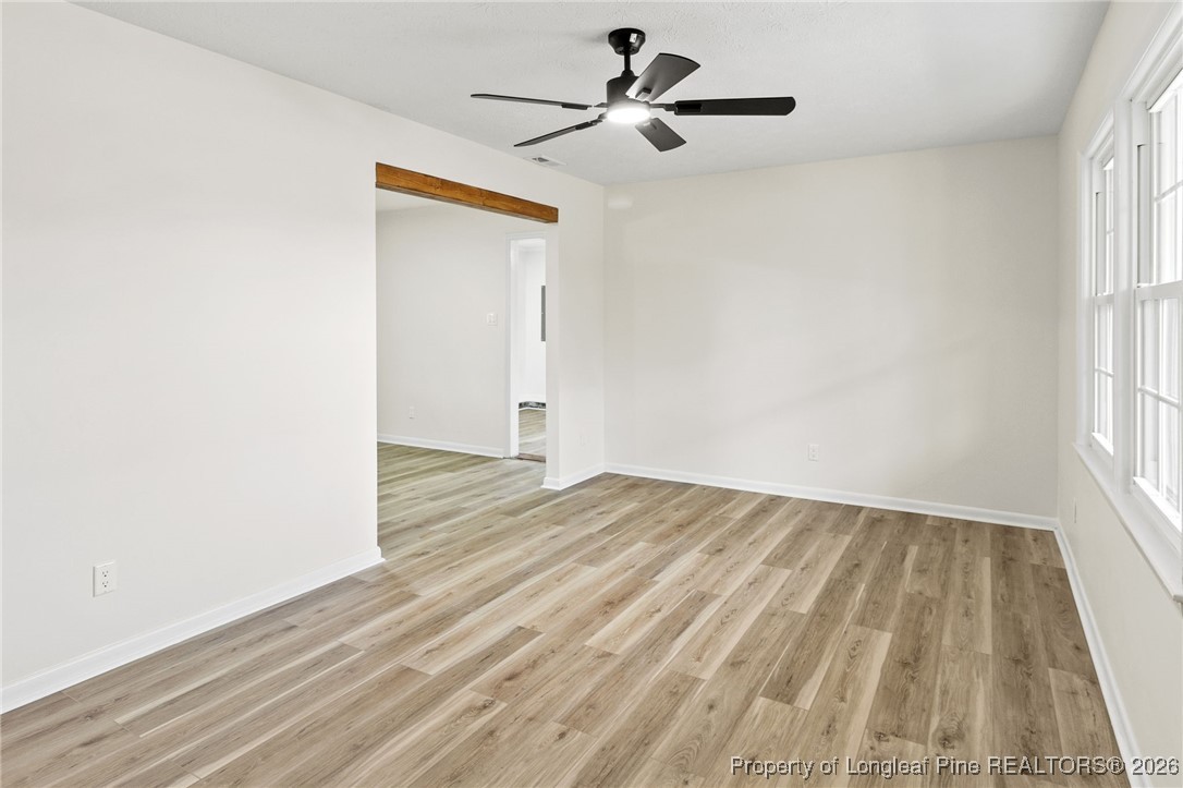 5982 Spinner Road Hope Mills, NC 28348 - Photo 6 of 32 an empty room with wooden floor chandelier fan and windows