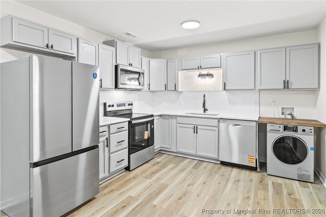 5982 Spinner Road Hope Mills, NC 28348 - Photo 8 of 32 a kitchen with stainless steel appliances a refrigerator sink and cabinets