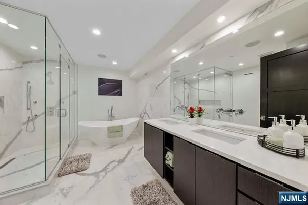 a bathroom with a double vanity sink mirror and shower