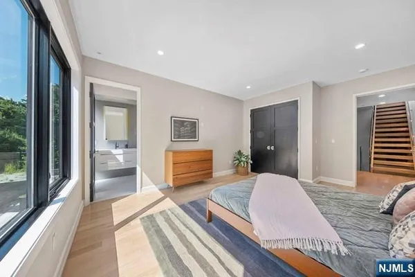 a spacious bedroom with a bed and wooden floor