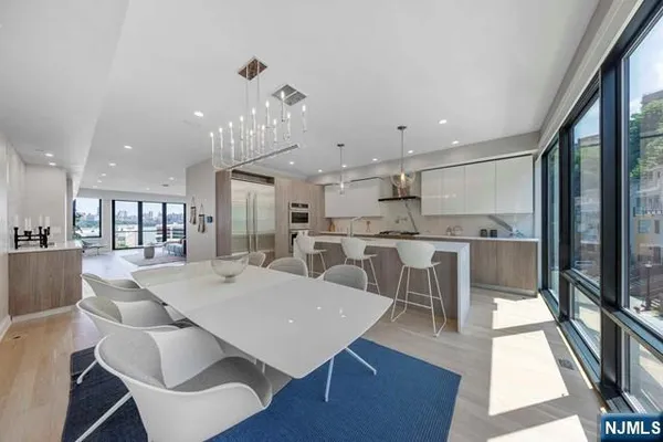 a view of a dining room with furniture a rug and wooden floor