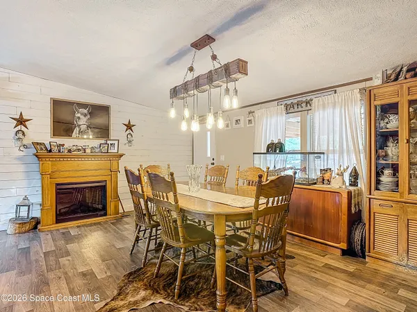 a dining room with furniture a fireplace and wooden floor