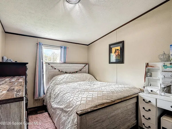 a bedroom with a bed and painting on the wall