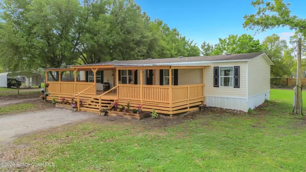 a view of a house with a yard and sitting area