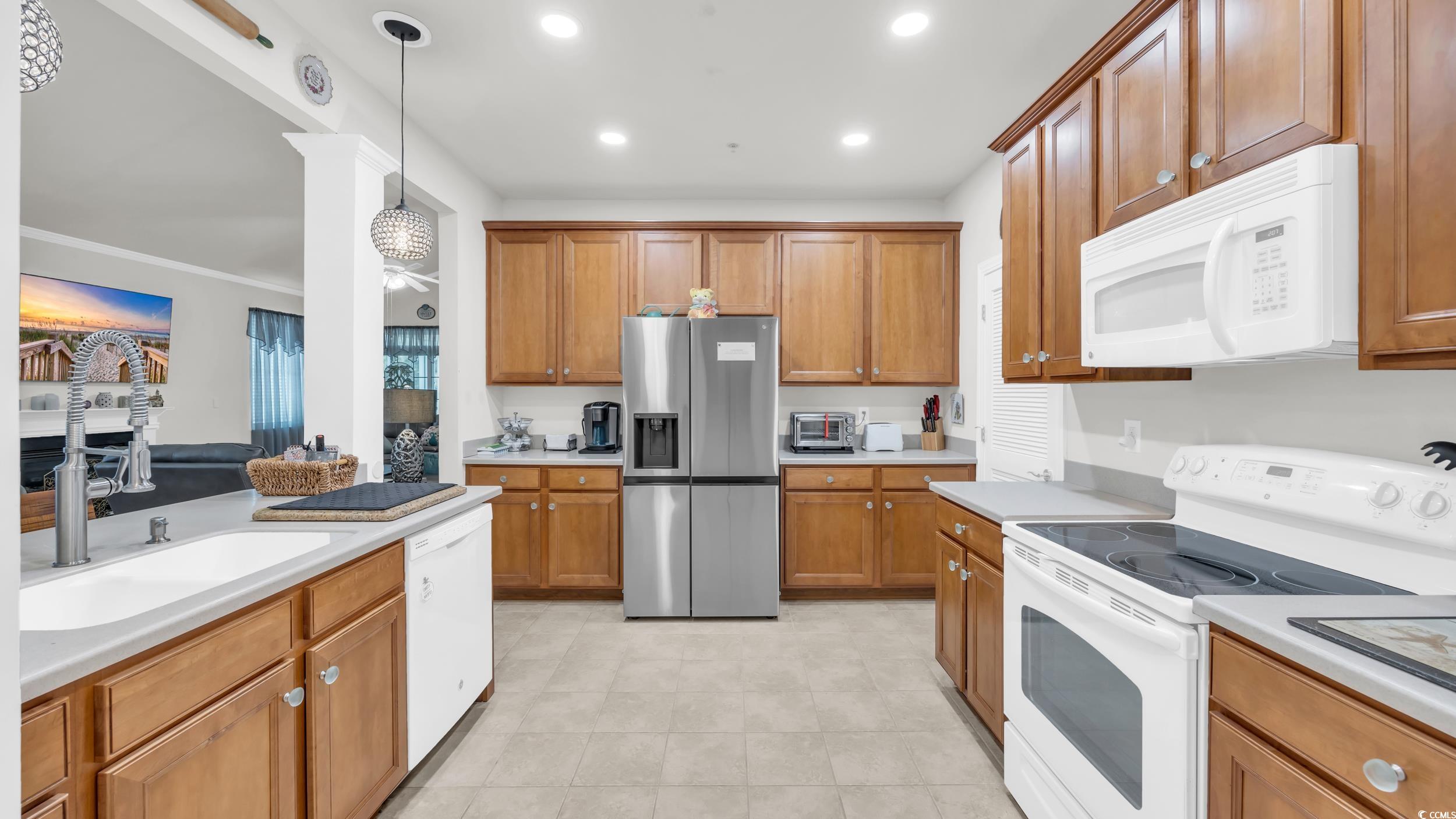 730 Pickering Drive, Unit 301 Murrells Inlet, SC 29576 - Photo 7 of 30 Kitchen with white appliances, brown cabinetry, light countertops, recessed lighting, and decorative light fixtures