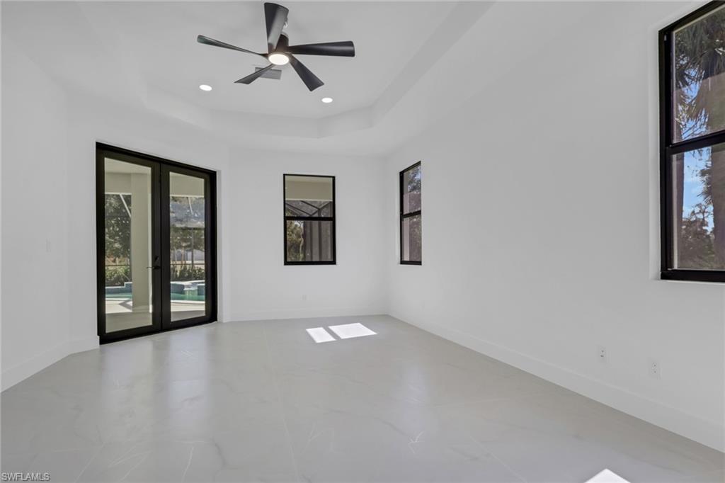 730 29th Street Southwest Naples, FL 34117 - Photo 25 of 50 Unfurnished room with french doors, a ceiling fan, a raised ceiling, and recessed lighting