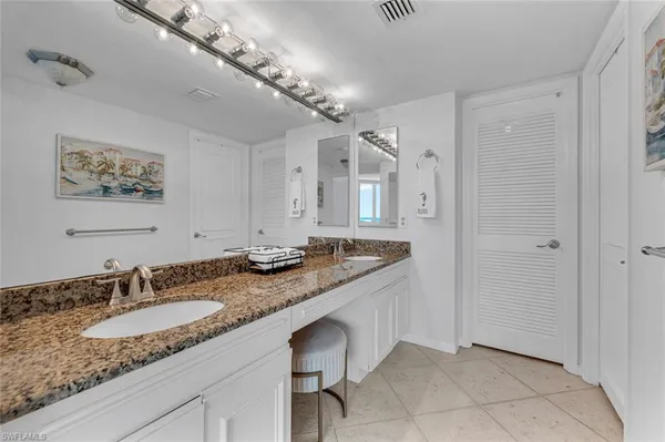 a bedroom with two beds and a large mirror next to a window