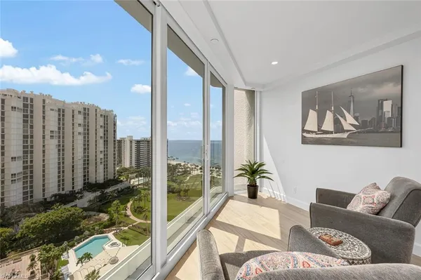 a view of a patio with couches chairs potted plants and ocean view