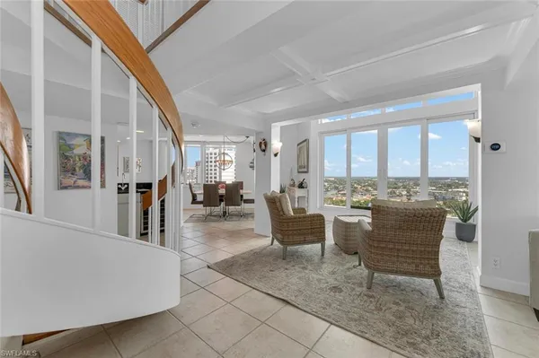 a living room with furniture and large windows
