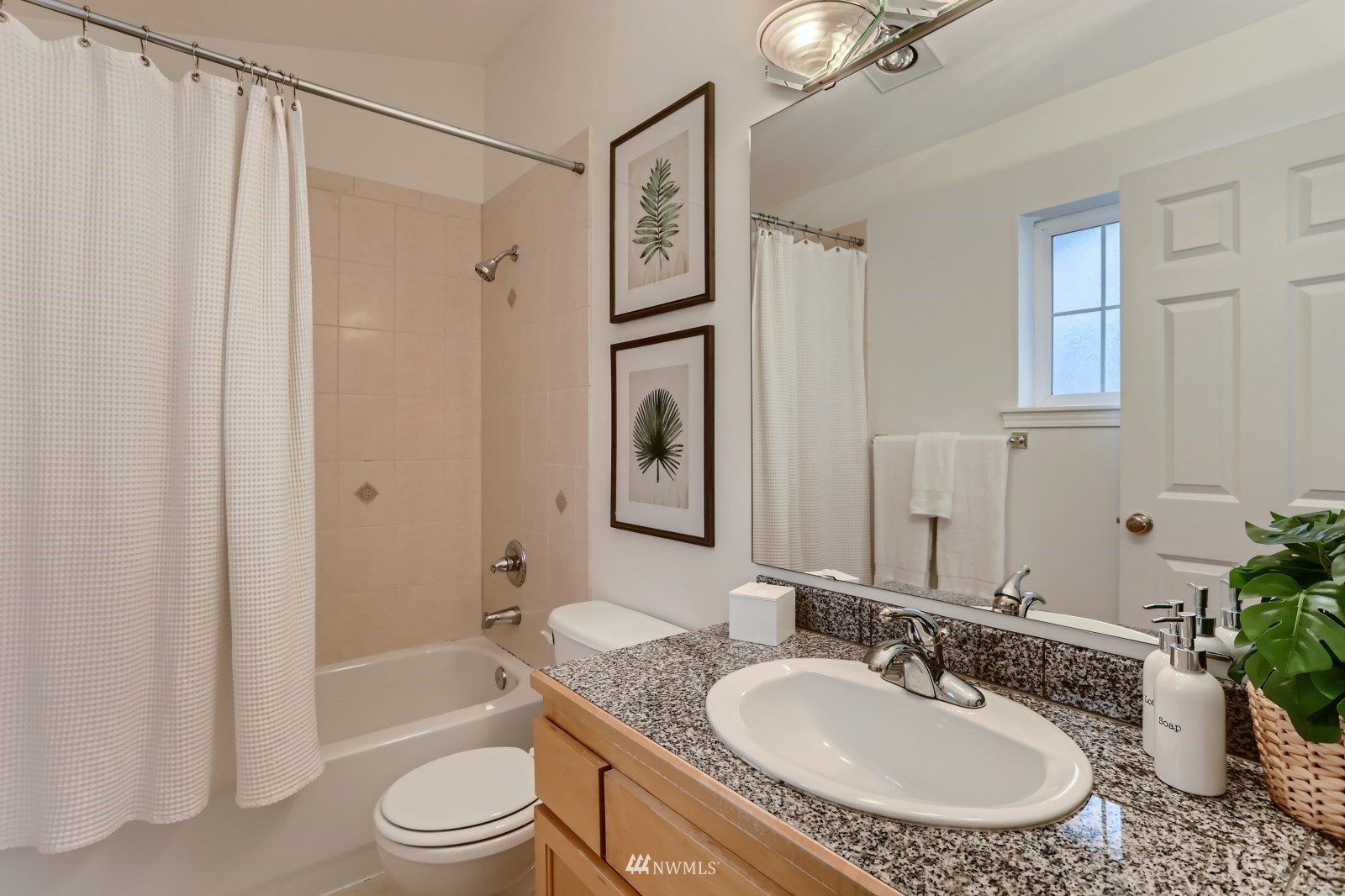 1512 Northwest 57th Street, Unit D Seattle, WA 98107 - Photo 18 of 29 a bathroom with a granite countertop sink toilet a mirror a vanity and shower