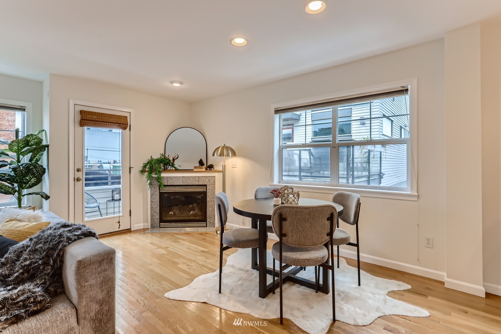 1512 Northwest 57th Street, Unit D Seattle, WA 98107 - Photo 6 of 29 a living room with furniture a dining table and a fireplace