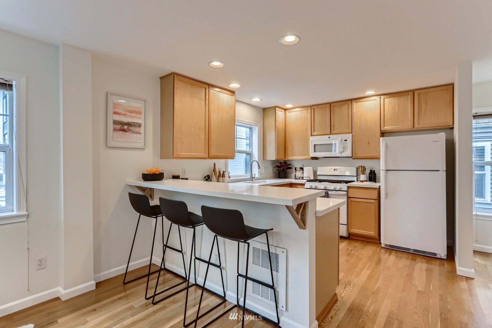 1512 Northwest 57th Street, Unit D Seattle, WA 98107 - Photo 8 of 29 a kitchen with refrigerator cabinets and wooden floor