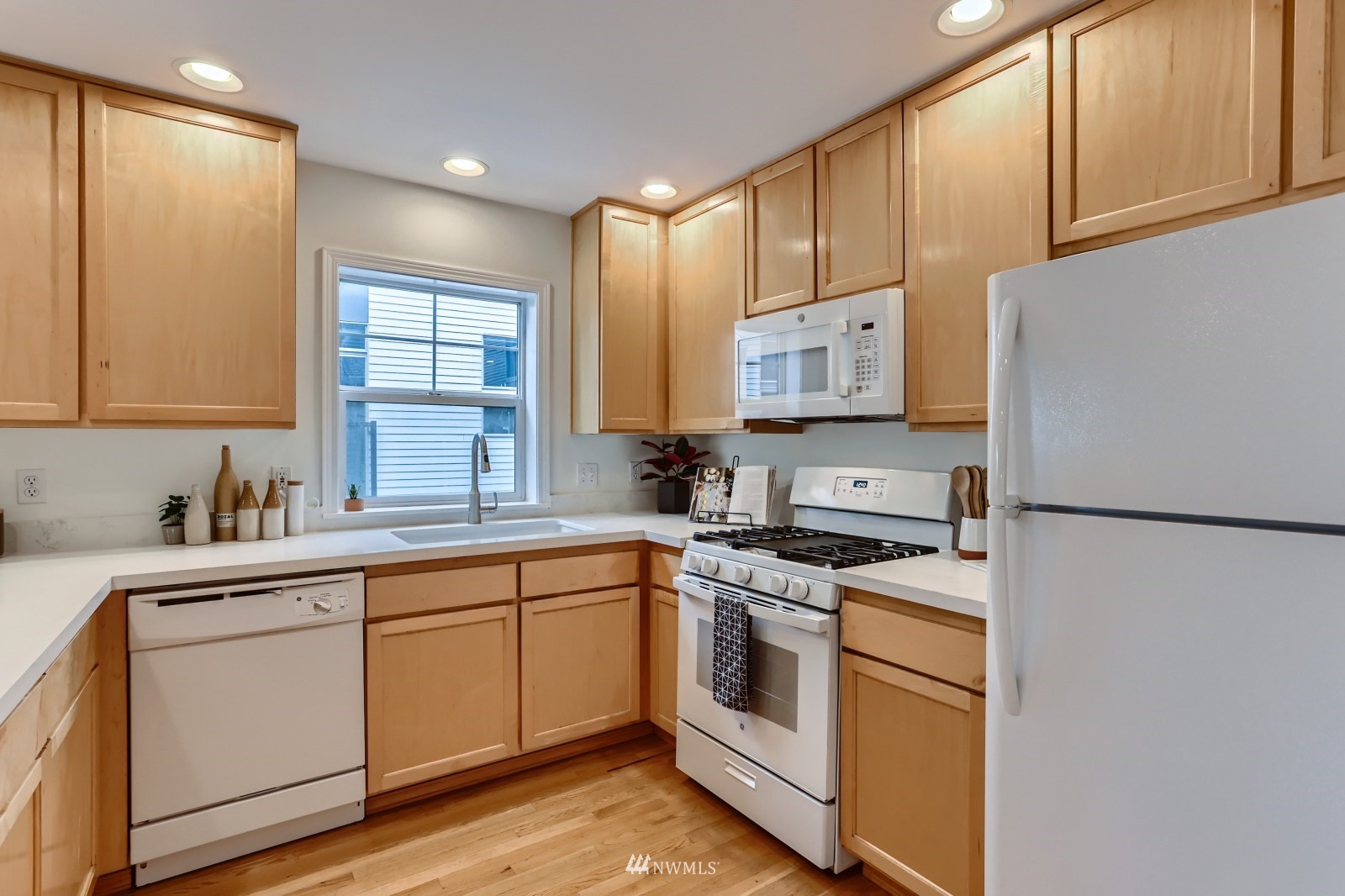 1512 Northwest 57th Street, Unit D Seattle, WA 98107 - Photo 9 of 29 a kitchen with a white cabinets and white appliances