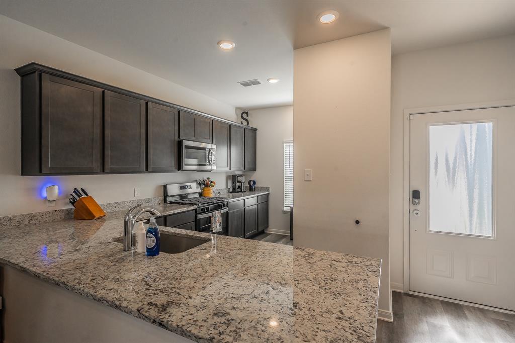 8125 White Sulphur Road Ponder, TX 76259 - Photo 6 of 38 Kitchen featuring granite countertops, dark wood-finish cabinetry, stainless steel appliances, and recessed lighting