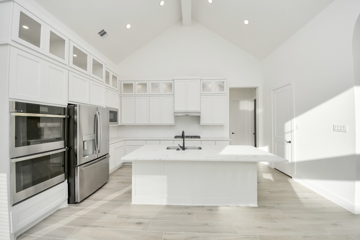9519 Chateau Hill Manvel, TX 77578 - Photo 11 of 35 a view of a kitchen with kitchen island a sink stainless steel appliances and cabinets
