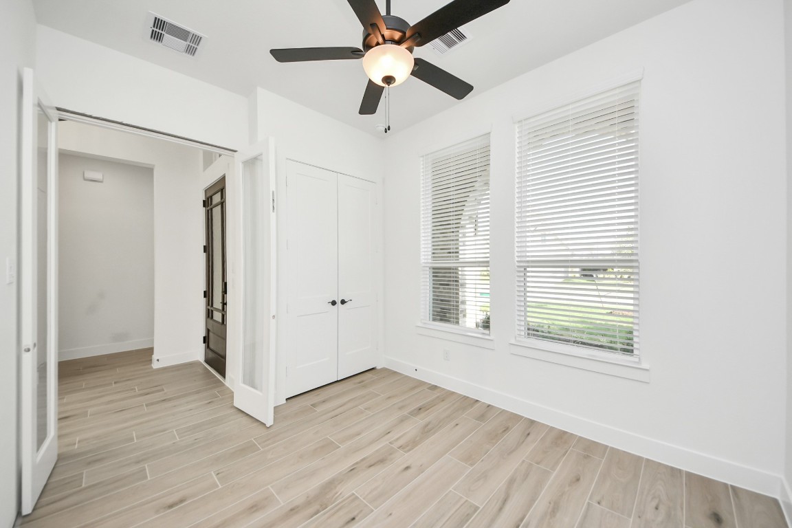 9519 Chateau Hill Manvel, TX 77578 - Photo 13 of 35 a view of an empty room with wooden floor and a window