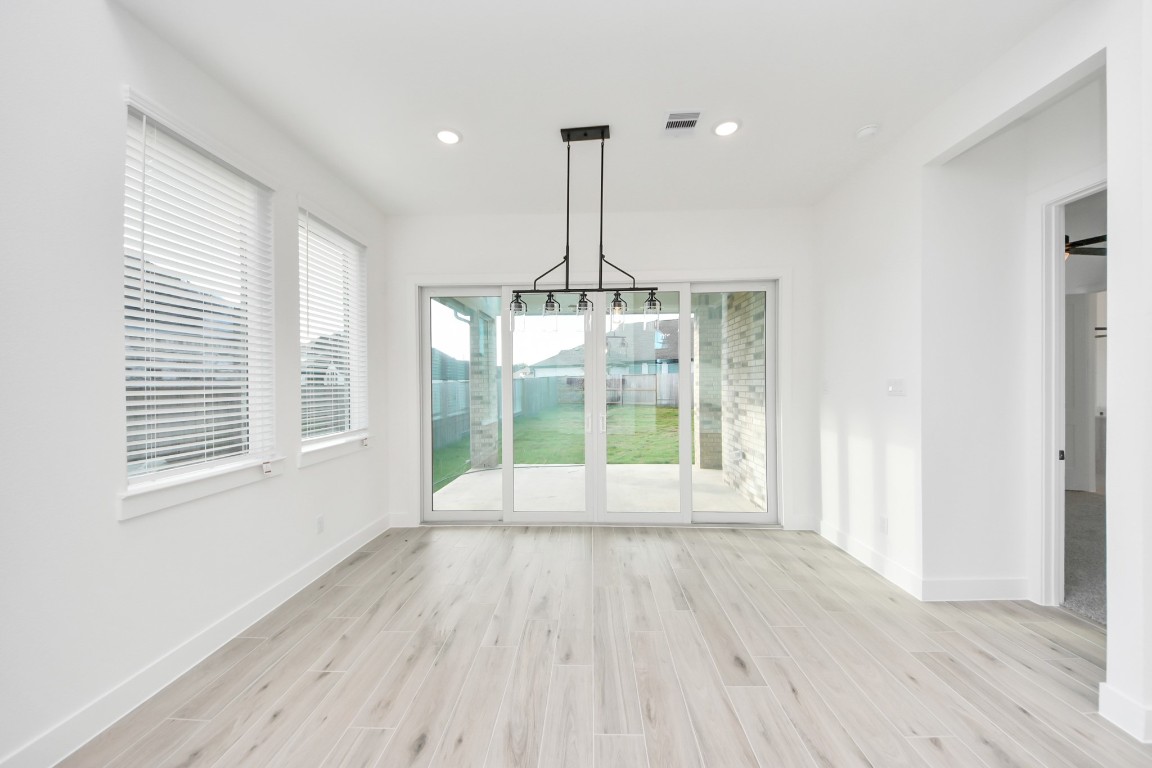 9519 Chateau Hill Manvel, TX 77578 - Photo 5 of 35 a view of an empty room with wooden floor and a window