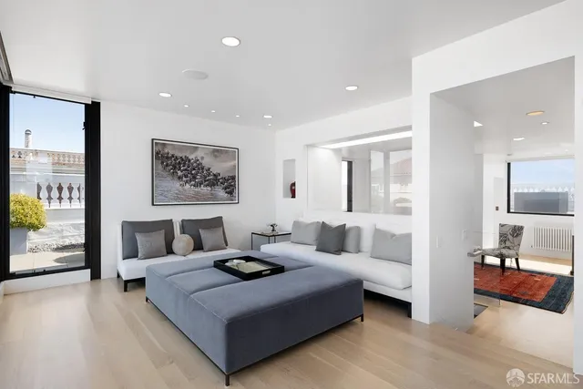 a spacious bedroom with a large bed and chandelier