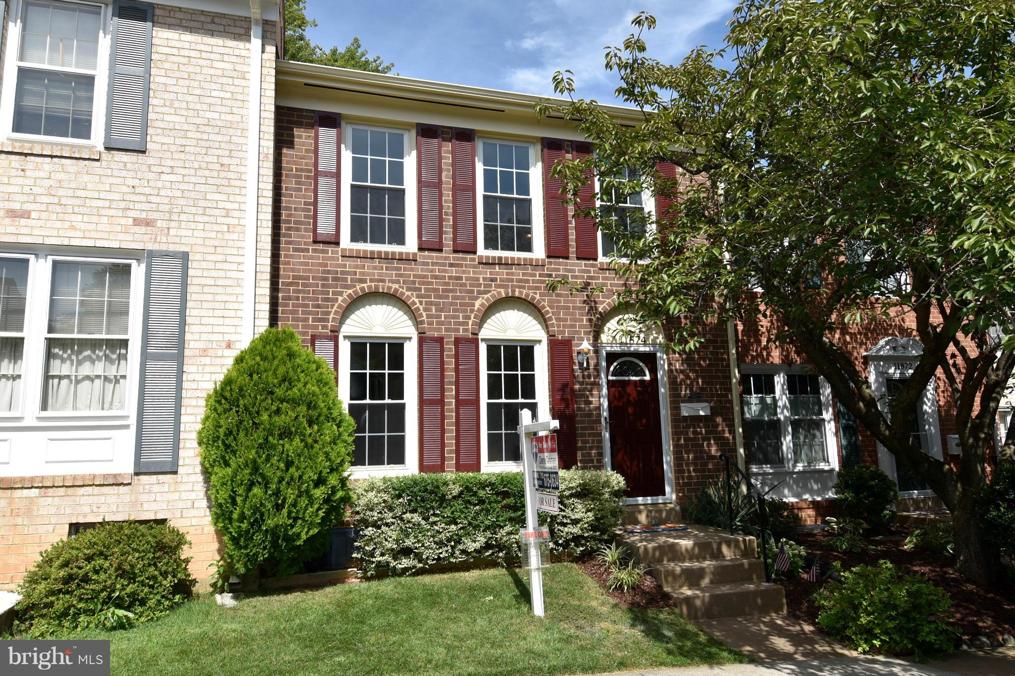 front view of a brick house with a yard