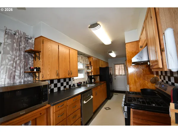 a kitchen with stainless steel appliances a sink stove and cabinets