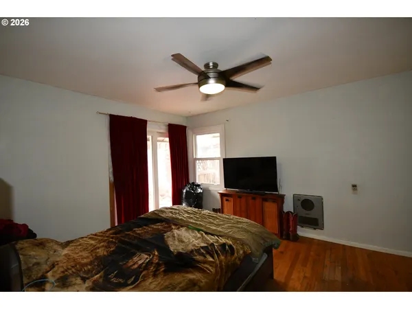 a bedroom with a bed and a flat tv screen on the dresser