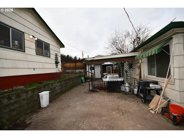 a backyard of a house with barbeque oven table and chairs