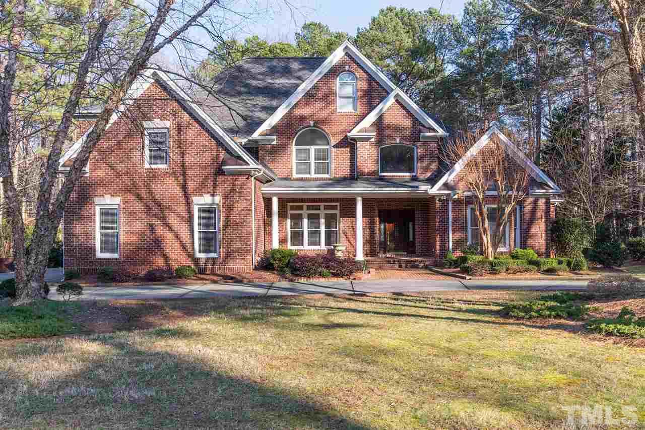 5220 Deergrass Court Raleigh, NC 27613 - Photo 2 of 25 a front view of a house with swimming pool and large trees