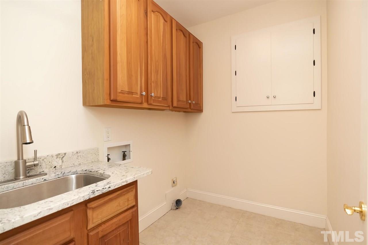 5220 Deergrass Court Raleigh, NC 27613 - Photo 12 of 25 a bathroom with a sink and cabinets