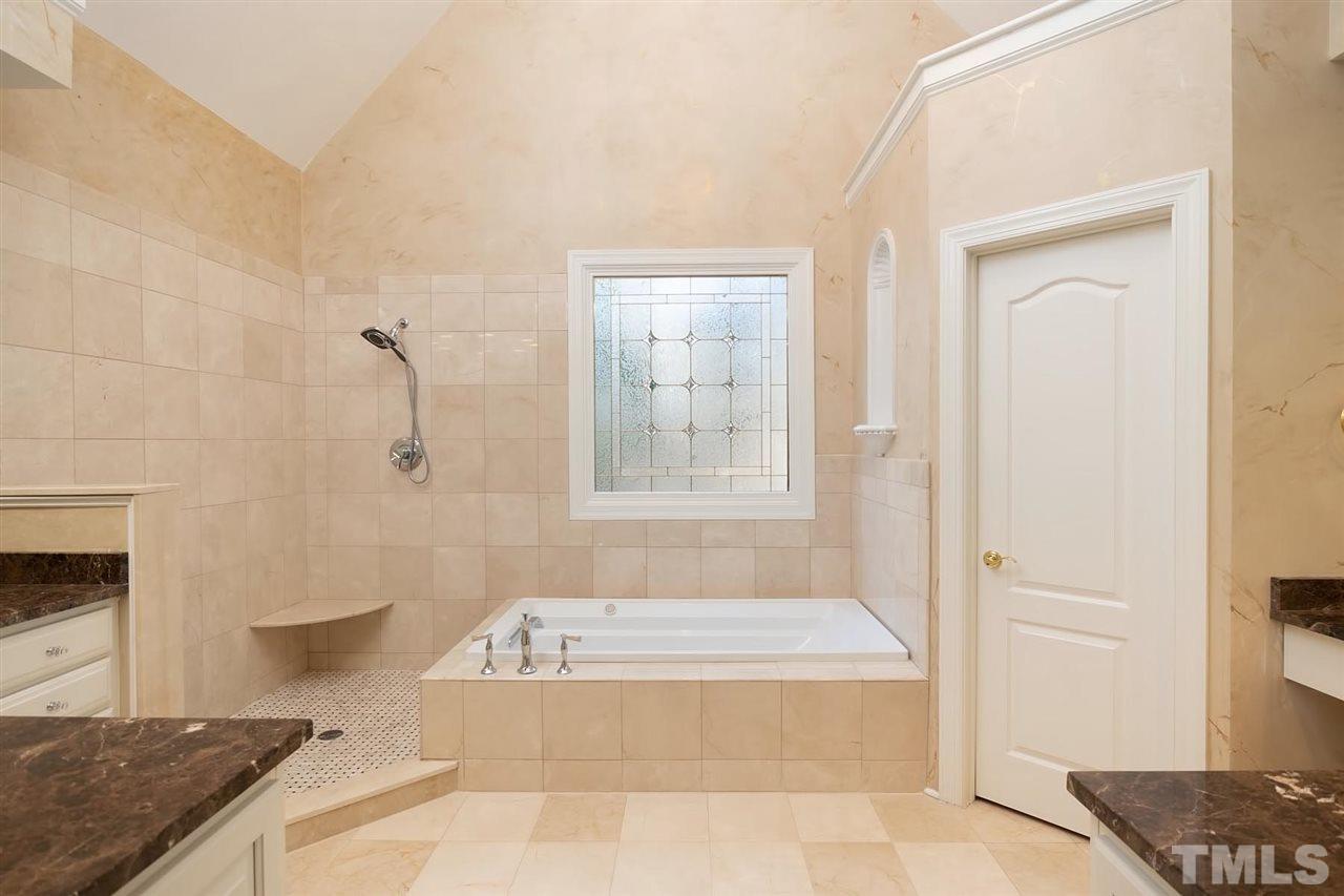5220 Deergrass Court Raleigh, NC 27613 - Photo 16 of 25 a bathroom with a granite countertop bathtub and shower