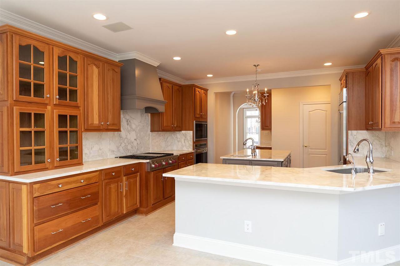 5220 Deergrass Court Raleigh, NC 27613 - Photo 7 of 25 a large kitchen with kitchen island a sink stainless steel appliances and cabinets