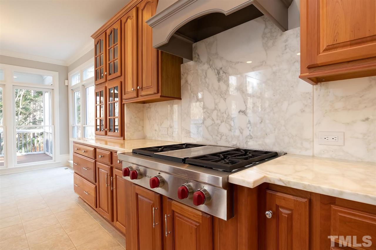 5220 Deergrass Court Raleigh, NC 27613 - Photo 9 of 25 a kitchen with granite countertop a stove and a sink