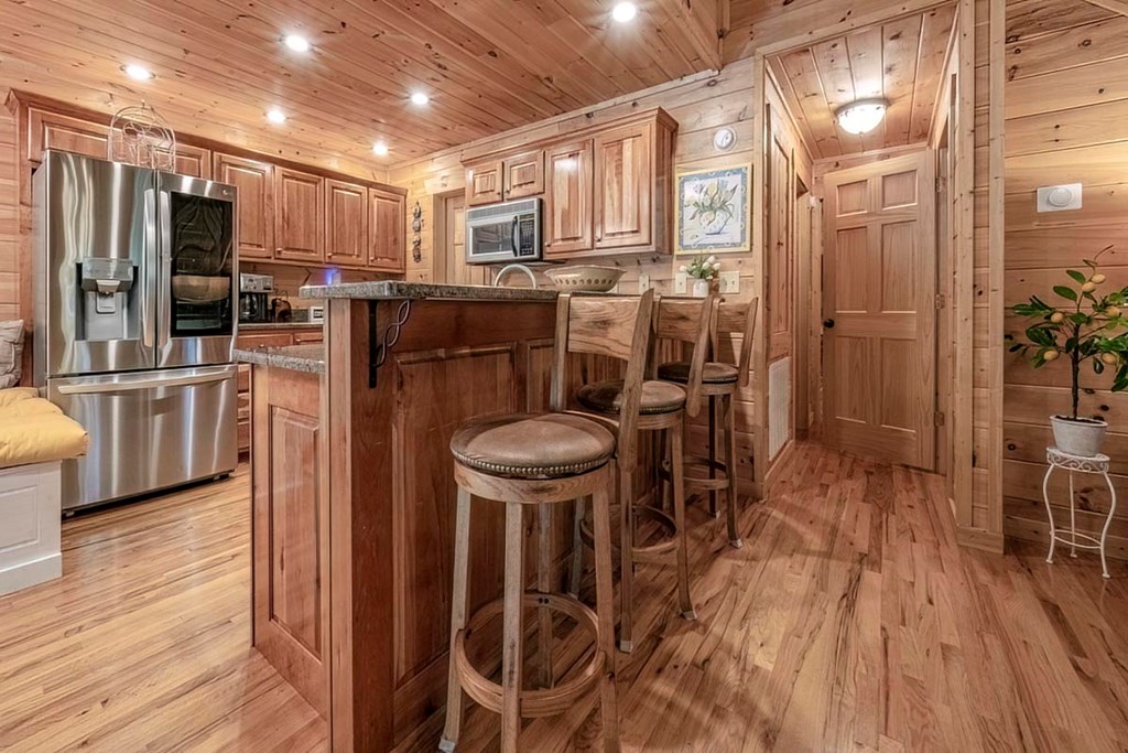 781 Mangum's Trail Blue Ridge, GA 30513 - Photo 11 of 65 a kitchen with stainless steel appliances a refrigerator a stove a sink dishwasher a dining table and chairs with wooden floor