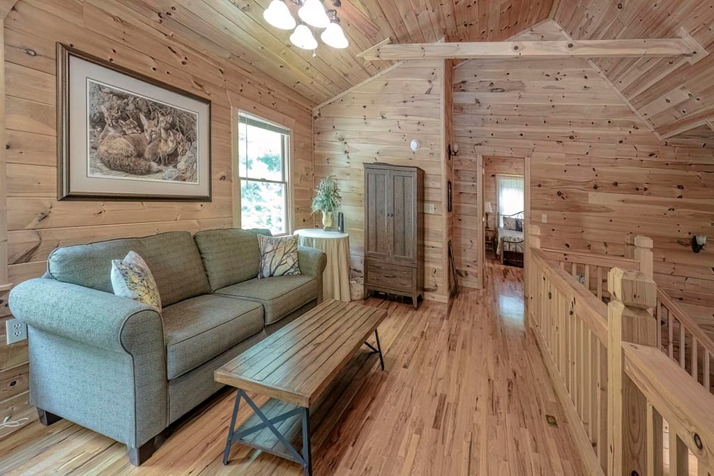 781 Mangum's Trail Blue Ridge, GA 30513 - Photo 31 of 65 a living room with furniture a wooden floor and a chandelier